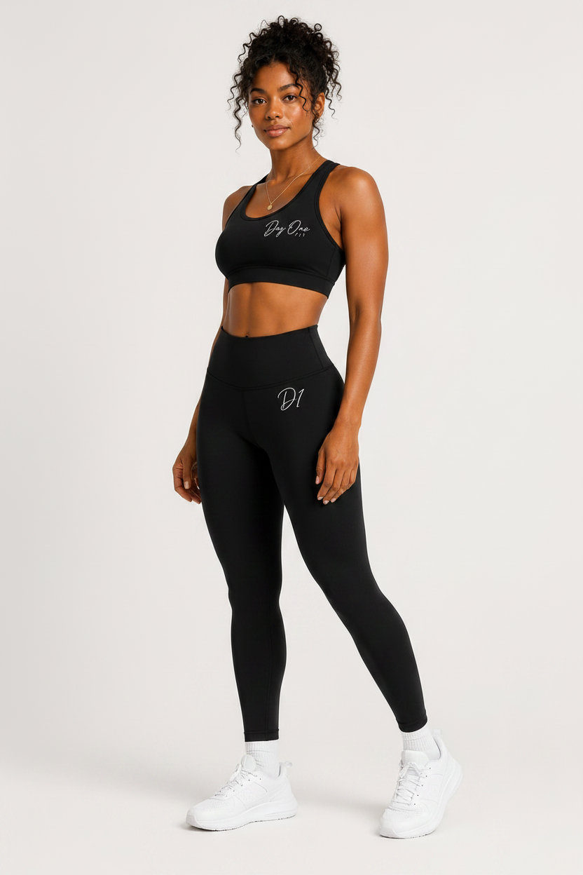 Woman wearing a black sports bra and leggings set on a white background