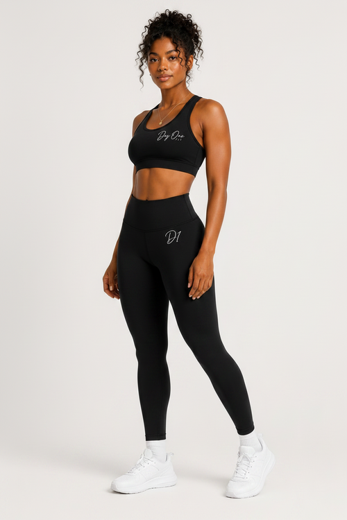 Woman wearing a black sports bra and leggings set on a white background